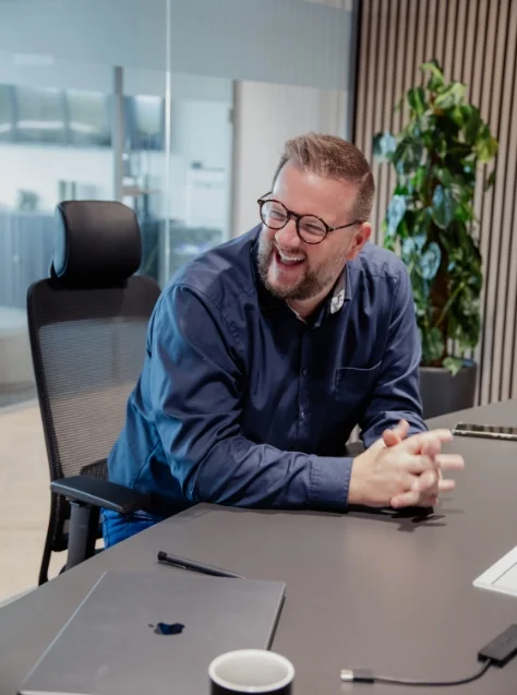 Your benefits Man with glasses laughing in conference room