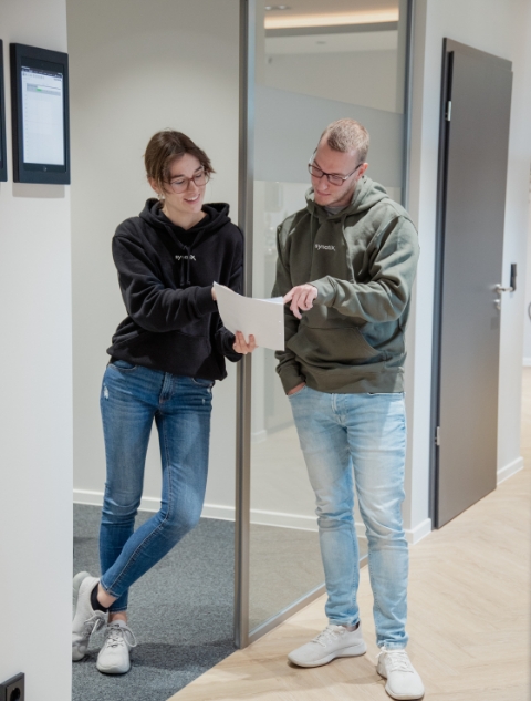 Colleagues look at documents at the door