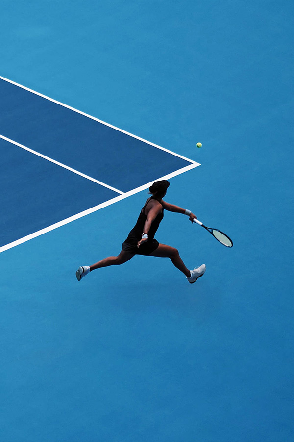 Tennisspielerin auf einem blauen Spielfeld