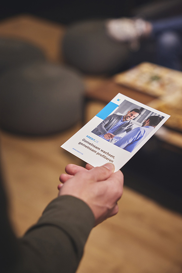 KREDIT.DE A flyer is held in one hand
